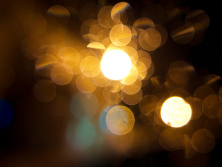 abstract black background, gold bubble lights or snowflakes falling at night. Bokeh Christmas...