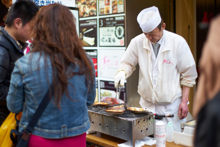 Osaka,Japan - 25 March,2015: Unidentified chefs prepare food for customers and tourists in front of their restaurant at Dotonbori Streetのeditorial素材