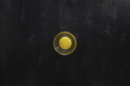 Black color wooden table top view. On the table are the fresh raw eggs in a glass bowl .の写真素材