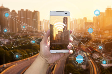 Hand holding white phone with city scape and interenet 
network connection conceptの写真素材