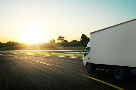 Truck traveling on road at sunrise - speed and delivery concept.の写真素材