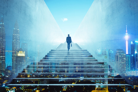 Rear view of a businessman climbing stairs to get to a large city center. Concept of success and appreciation. Double exposureの写真素材