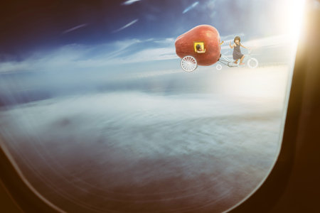 Happy sister enjoy with fantasy apple bike ,seen through window of an aircraft , dreams and travel concept .の写真素材