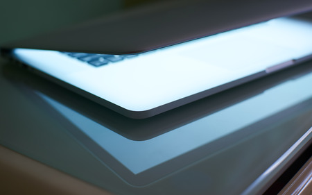 Abstarct closeup angle laptop half close with white screen .Low Key lighting and  selected focus.の写真素材