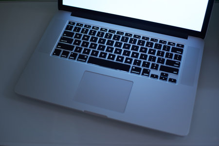 Laptop keyboard close up with white copy space screen . Low Key lighting and  selected focus.