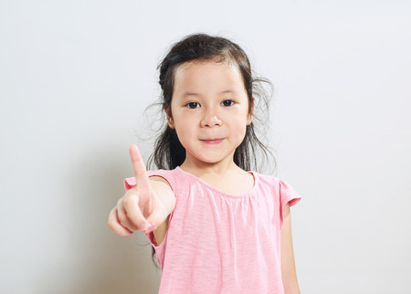 Portrait of young asian cute girl shows a finger One pose .の写真素材