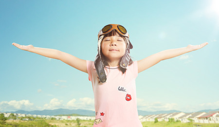 Little asian girl wear aviator glasses and enjoy her travel dreams , summer sky background .の写真素材