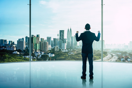 The businessman was very excited in the office with modern city skyline .の写真素材