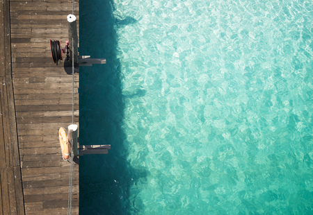Wooden jetty with crystal clear and turquoise sea water of the tropical sea . Aerial top view .Rawa island , Malaysia .の写真素材