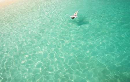 Woman snorkling and relaxing crystal clear and turquoise sea water of the tropical sea .の写真素材