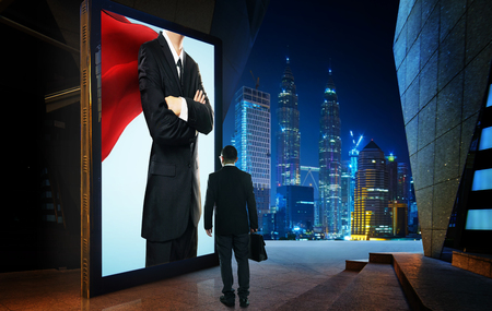 Young businessman looking the hero businessman on the advertising billboard screen . Successful businessman concept .の写真素材