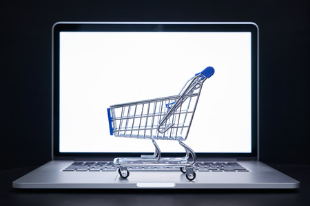Shopping cart or trolley in front of Laptop , online marketing and business trading concept.の写真素材