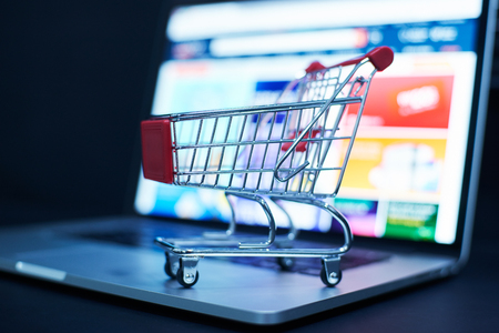 Shopping cart or trolley in front of Laptop , online marketing and business trading concept.の写真素材