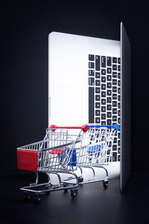 Laptop open like door with a empty shopping cart , online marketing and business trading concept.の写真素材