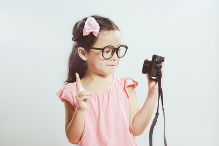 Little asian cute girl selfie with retro camera .  Vintage mint green wall background.の写真素材