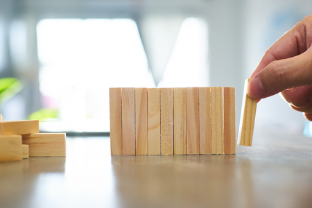 Hand of engineer playing a wood block . Growth in business and goal concept.の写真素材