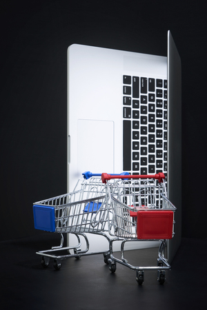 Laptop open like door with a empty shopping cart , online marketing and business trading concept.の写真素材