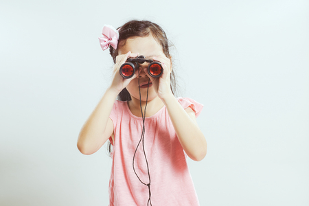 Beautiful little young cute asian girl using telescope looking forward .の写真素材