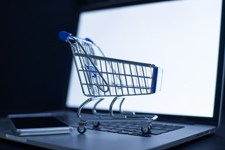 Shopping cart or trolley in front of Laptop , online marketing and business trading concept.の写真素材