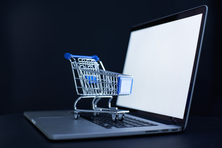 Shopping cart or trolley in front of Laptop , online marketing and business trading concept.の写真素材