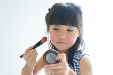 Little asian chinese girl learning makeup .の写真素材