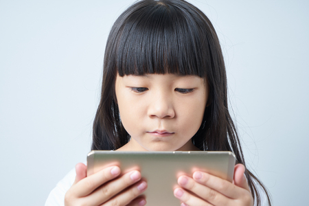 Little asian chinese girl using smartphone .の写真素材