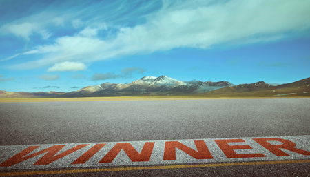 View of the empty asphalt road with winner word and beautiful mountain landscape . Evening scene .の写真素材
