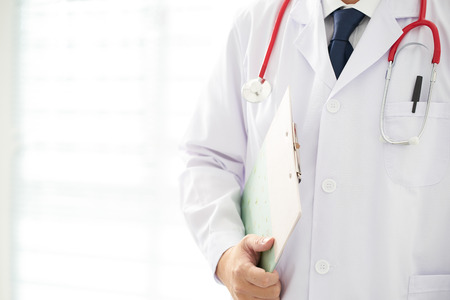 Doctor with a stethoscope and taking notes with bright background .の写真素材