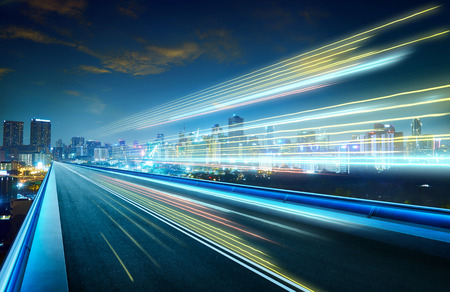 Empty asphalt flyover with city skyline and light trails ,night scene .の写真素材