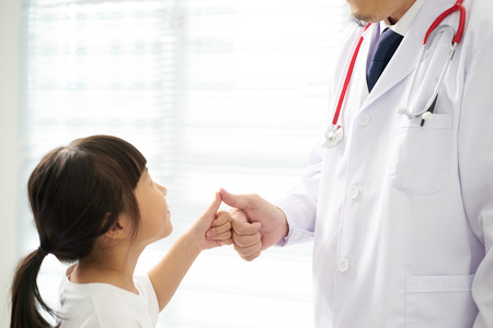 Unknown doctor and little girl shaking hands .の写真素材
