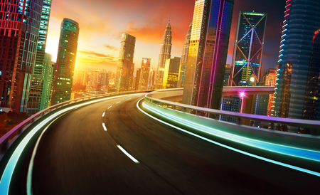 Highway overpass motion blur with city skyline and urban skyscrapers , golden hour scene.の写真素材