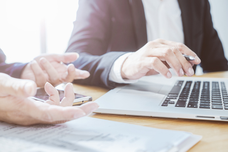 Two businessman using laptop to discuss finance and marketing solution .の写真素材