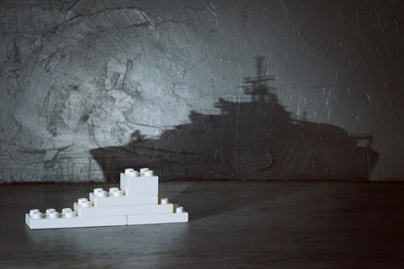 Plastic building blocks with ship shadow . Creative and ideal concept . Concrete interior background .の写真素材