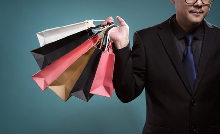 Close up of man with shopping bags , isolated on light blue background .の写真素材