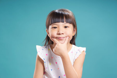 Little cute asian girl using two finger making smile .