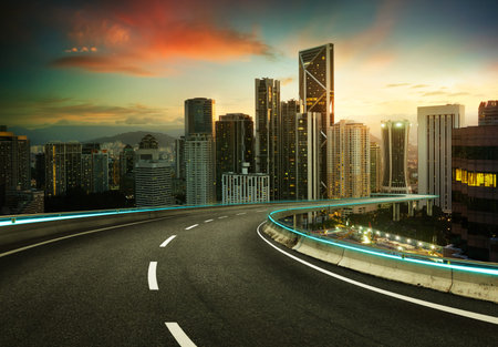 Blue neon light design highway overpass with modern city background .Early morning scene .の写真素材