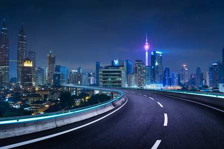 Blue neon light design highway overpass with modern city background . Night scene .の写真素材