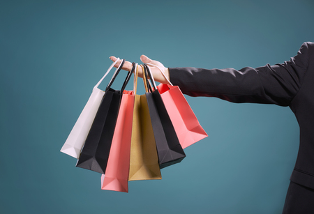 Close up of man hand with shopping bags , isolated on light blue background .の写真素材