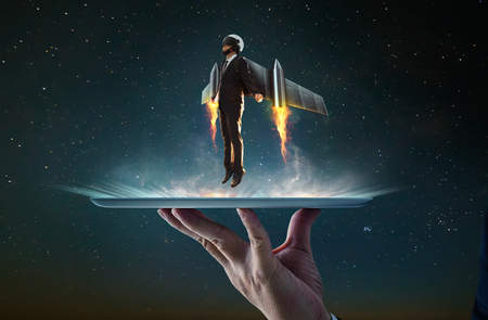 Waiter hand holding an empty digital tablet with Businessman wear a rocket suit to lift , Business success concept .の写真素材