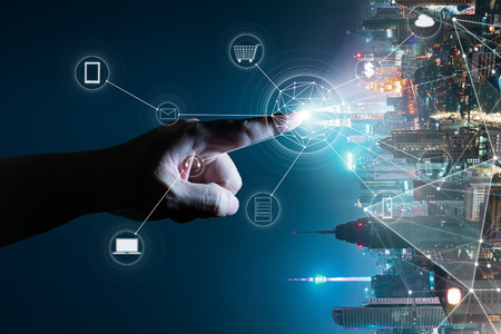 Unknown hand touching the light came out from the ground ,flip modern city background with wireless network connection concept , abstract communication technology image visual .の写真素材