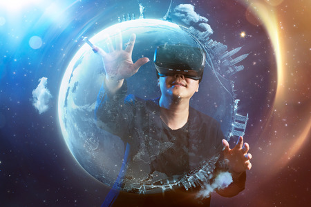 The young man wearing virtual reality goggles with amazing cosmic futuristic space virtual imaging background .の写真素材