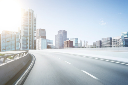 Motion blur flyover asphalt road with modern skyscraper building background.の写真素材