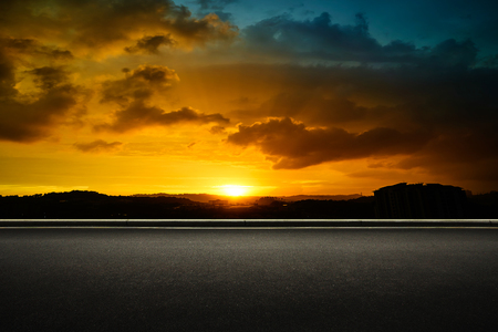 Asphalt road side with dramatic blue and orange color cloudy sunset golden hour .の写真素材