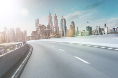 Motion curvy flyover asphalt highway road with modern cityscape skyline view  . Sunrise scene .の写真素材