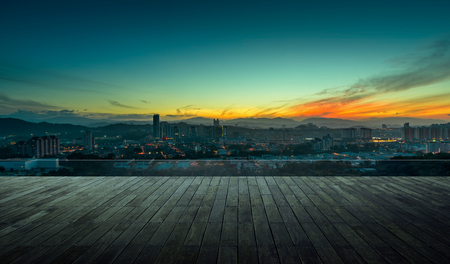 Wooden balcony terrace with early morning silhouette city skyline .の写真素材