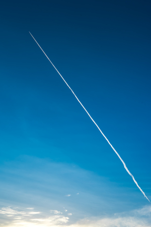 airplane contrail against clear blue skyの写真素材
