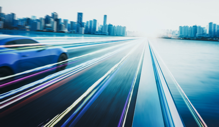 3D rendering of a brand-less blue sport car with light effect and motion blur . City skyline background . Sunset scene .の写真素材