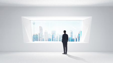 Thoughtful businessman standing in empty space concrete room with bright window and cityscape view . Mixed media .の写真素材