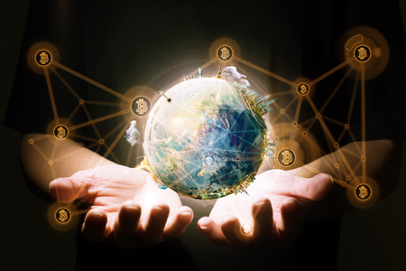 Closeup hand holding virtual earth with blockchain network connection . Electronic money ,blockchain transfers and finance concept.の写真素材