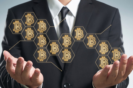 Businessman holding blockchain network connection with blur night city background .Electronic money ,blockchain transfers and finance concept.の写真素材